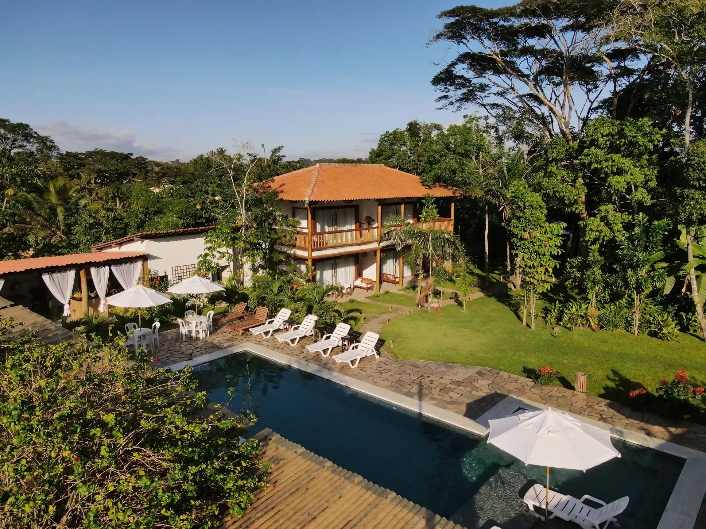 Uma casa grande com uma piscina na frente - pousada-recanto-caxando
