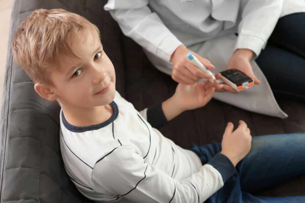 Doctor Using Lancet Pen And Digital Glucometer To Check Diabetic Boy's Blood Sugar Level — Diabetes Services in Wulguru, QLD