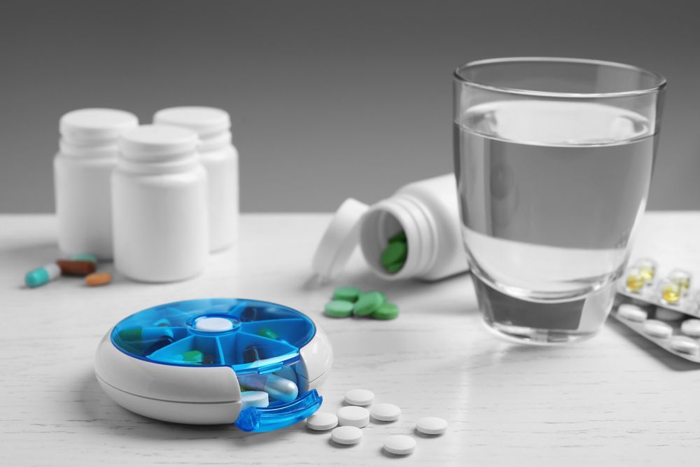 Pill Box With Medicaments On White Wooden Table — Personal Medication Packs in Wulguru, QLD