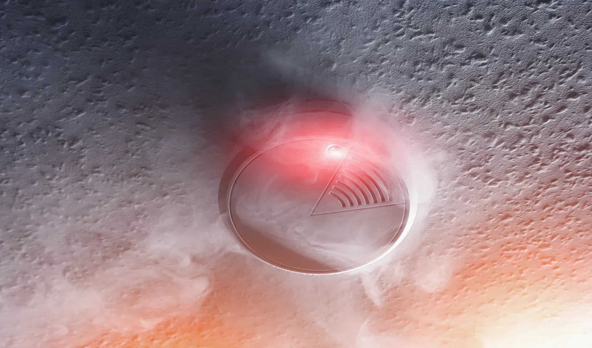 Close-up of a red glowing smoke detector on a white textured ceiling.  — Anthony Cameron Electrical & Solar In Woodgate, QLD
