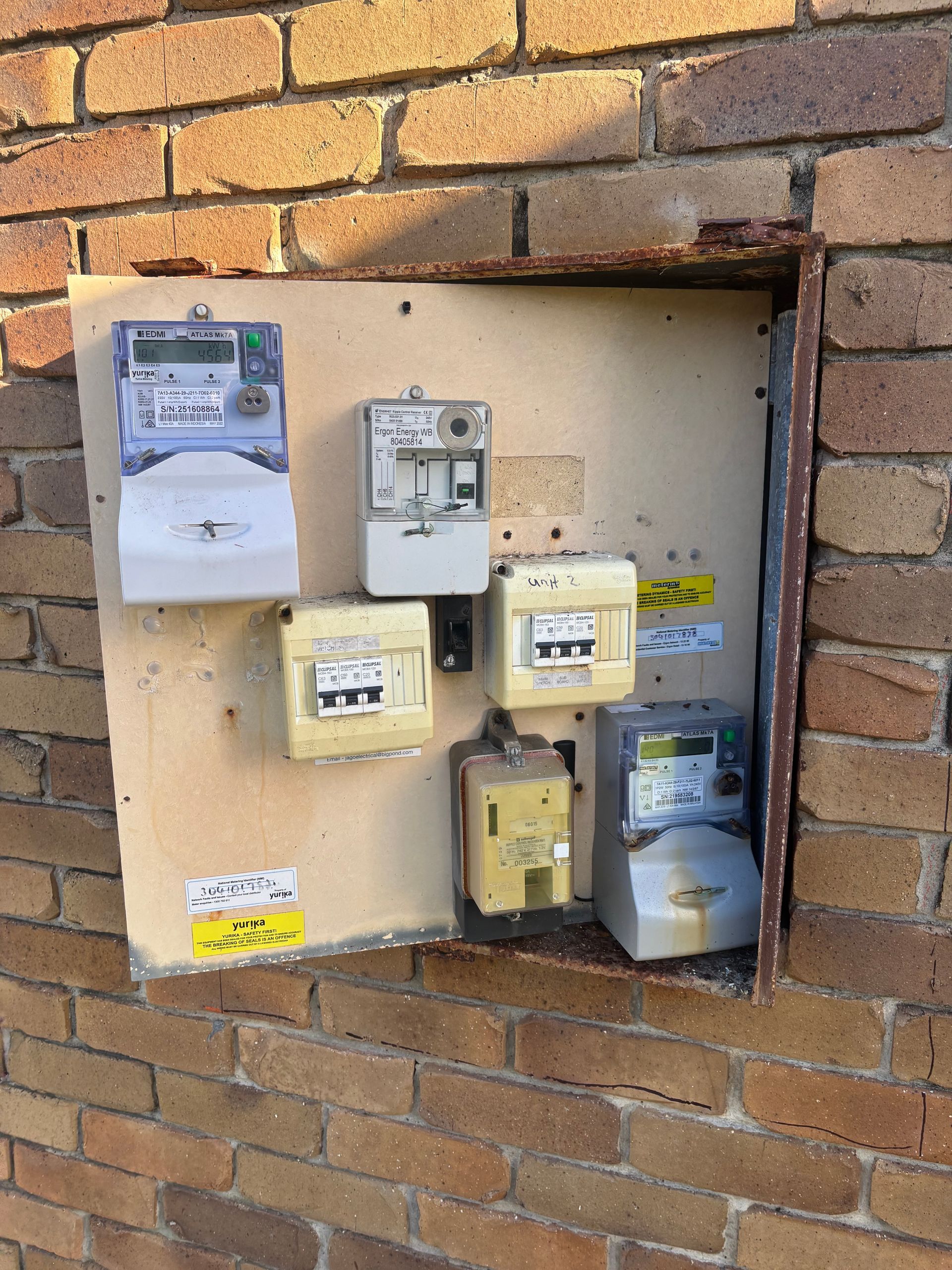 Gas and electric meters mounted on a brick wall in a recessed utility box — Anthony Cameron Electrical & Solar In Kepnock, QLD