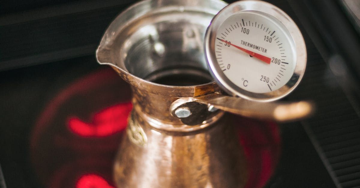 a scoville scale thermometer is sitting on top of a pot on a stove . a scoville scale thermometer is sitting on top of a pot on a stove .