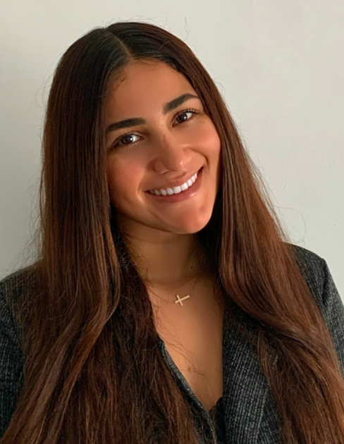 A woman with long brown hair is smiling for the camera.