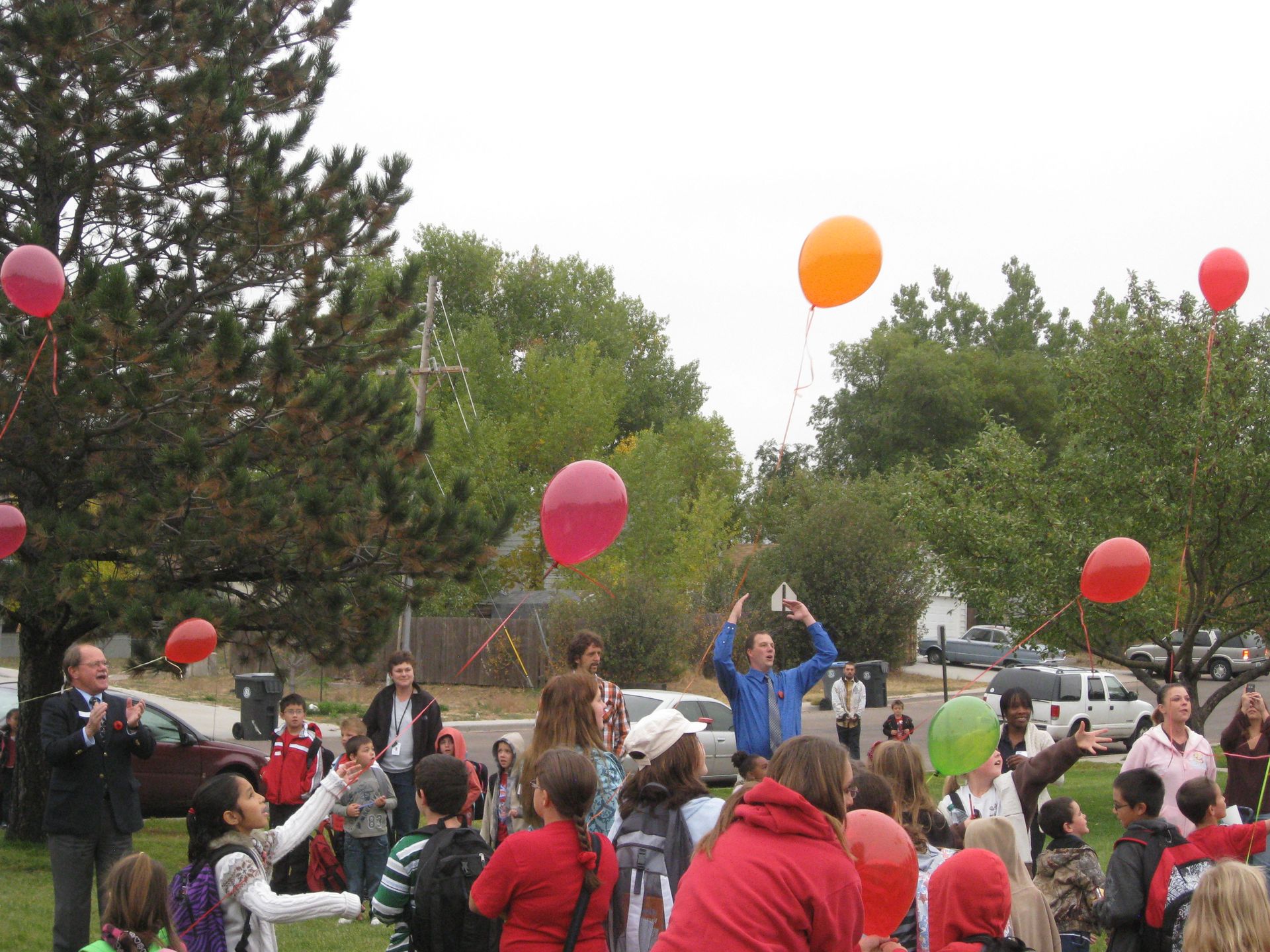 People releasing colorful balloons outdoors.