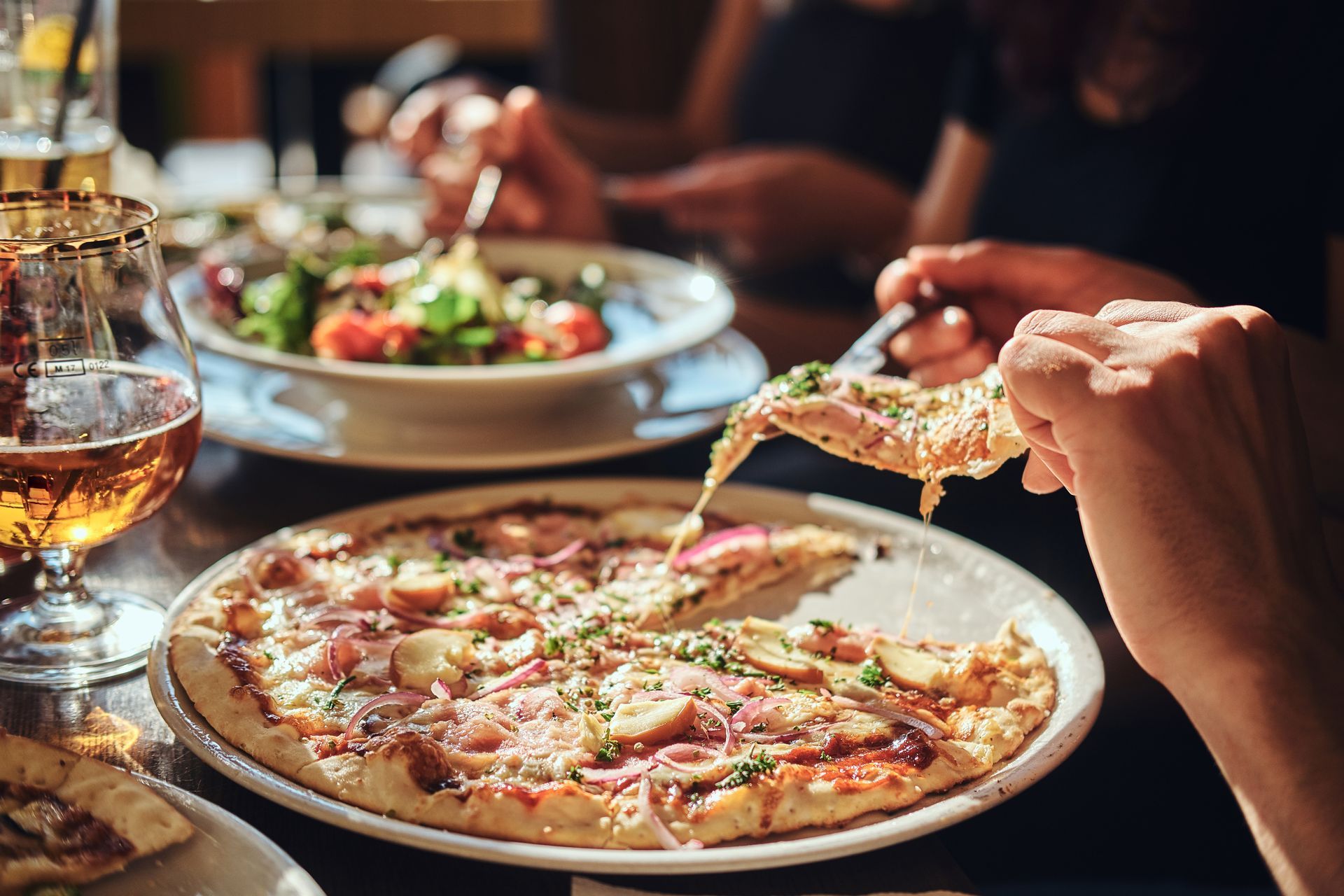 A Person Lifting A Pizza Slice.