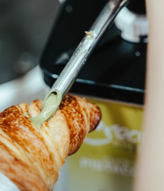 Un dolce spennellato con una glassa verde usando un pennello da pasticceria