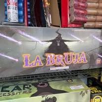 Shelf display of “La Bruja” packaging with a dark witch graphic and bold purple-orange lettering