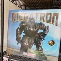 Megatron toy box with a dark robot figure and metallic gold title on a blue background