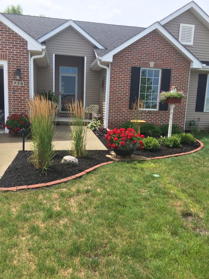 Fresh mulch being installed in residential flower bed by CD’s Lawn Care