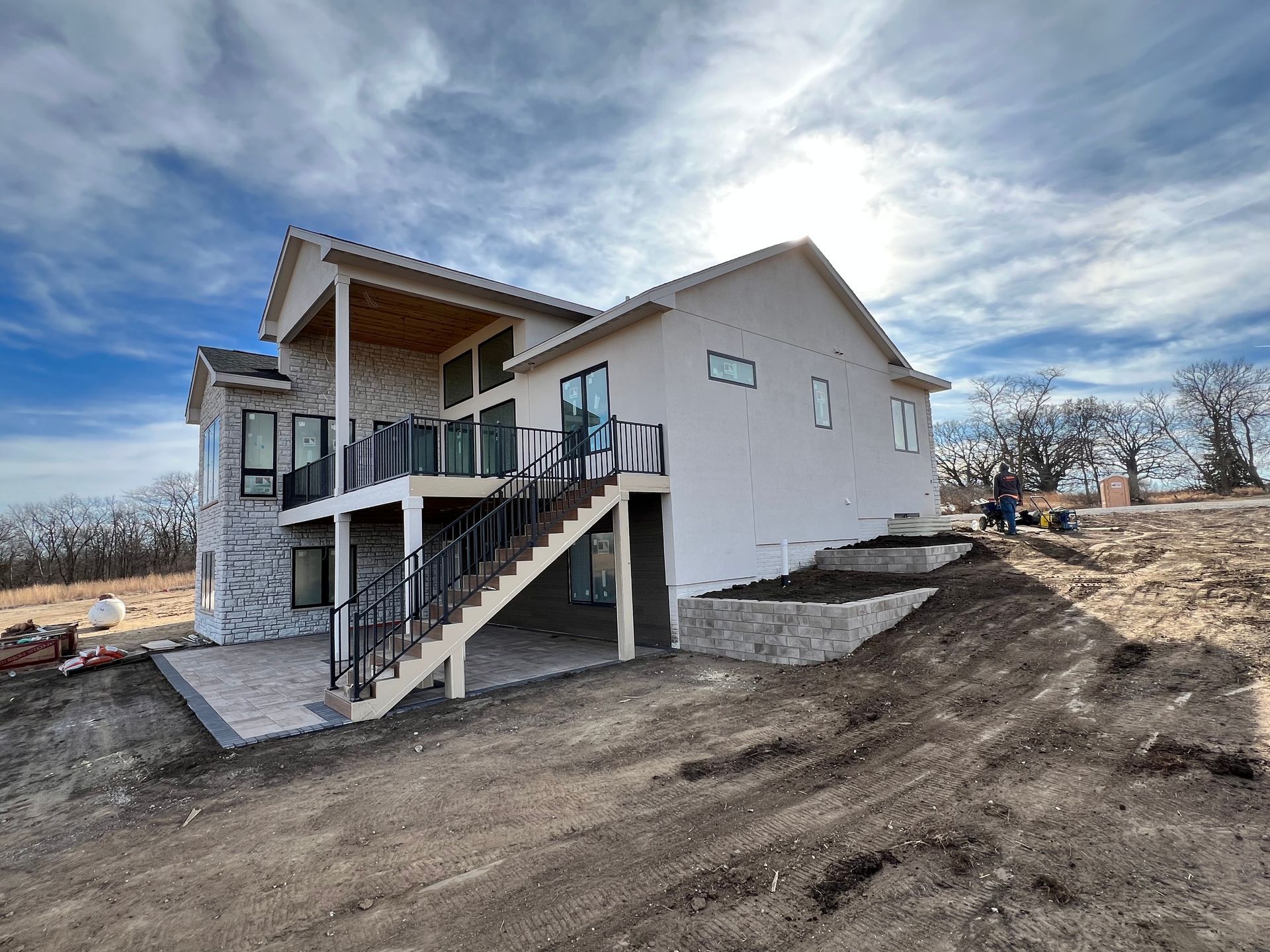 Built-in patio under attached deck with rock retaining walls by CD’s Lawn Care in Central Iowa