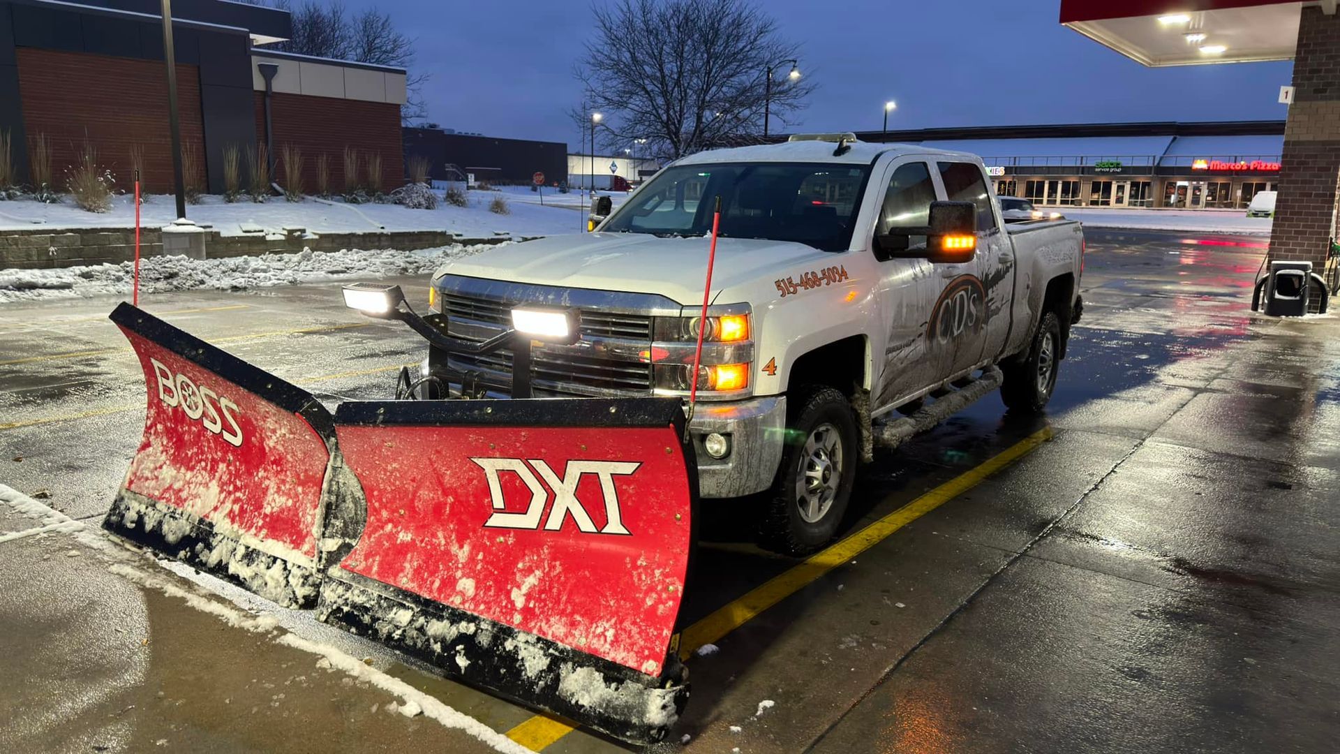 CD’s Lawn Care truck plowing snow with V-blade on a Central Iowa commercial lot