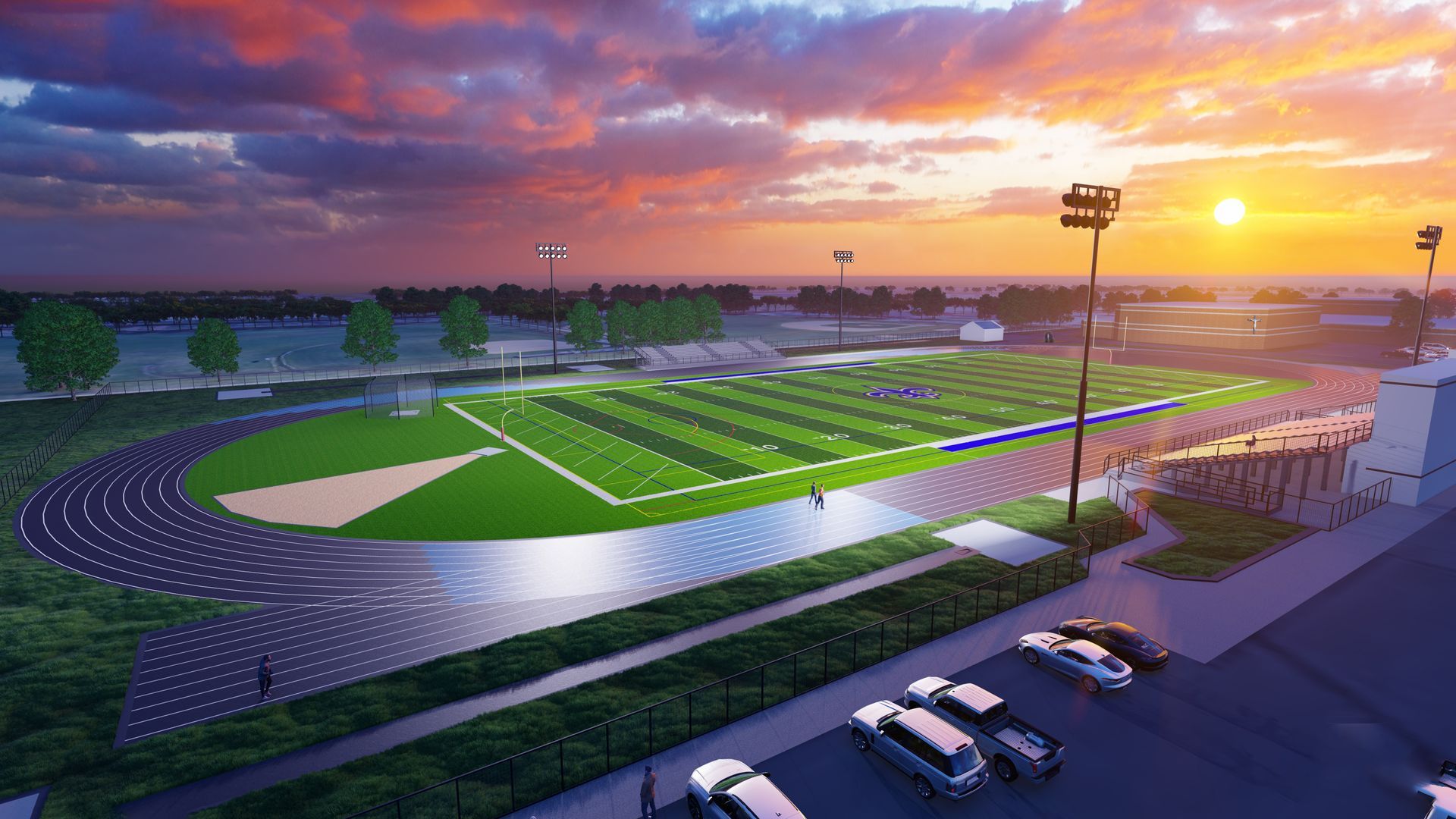 An aerial view of a football field and track at sunset.