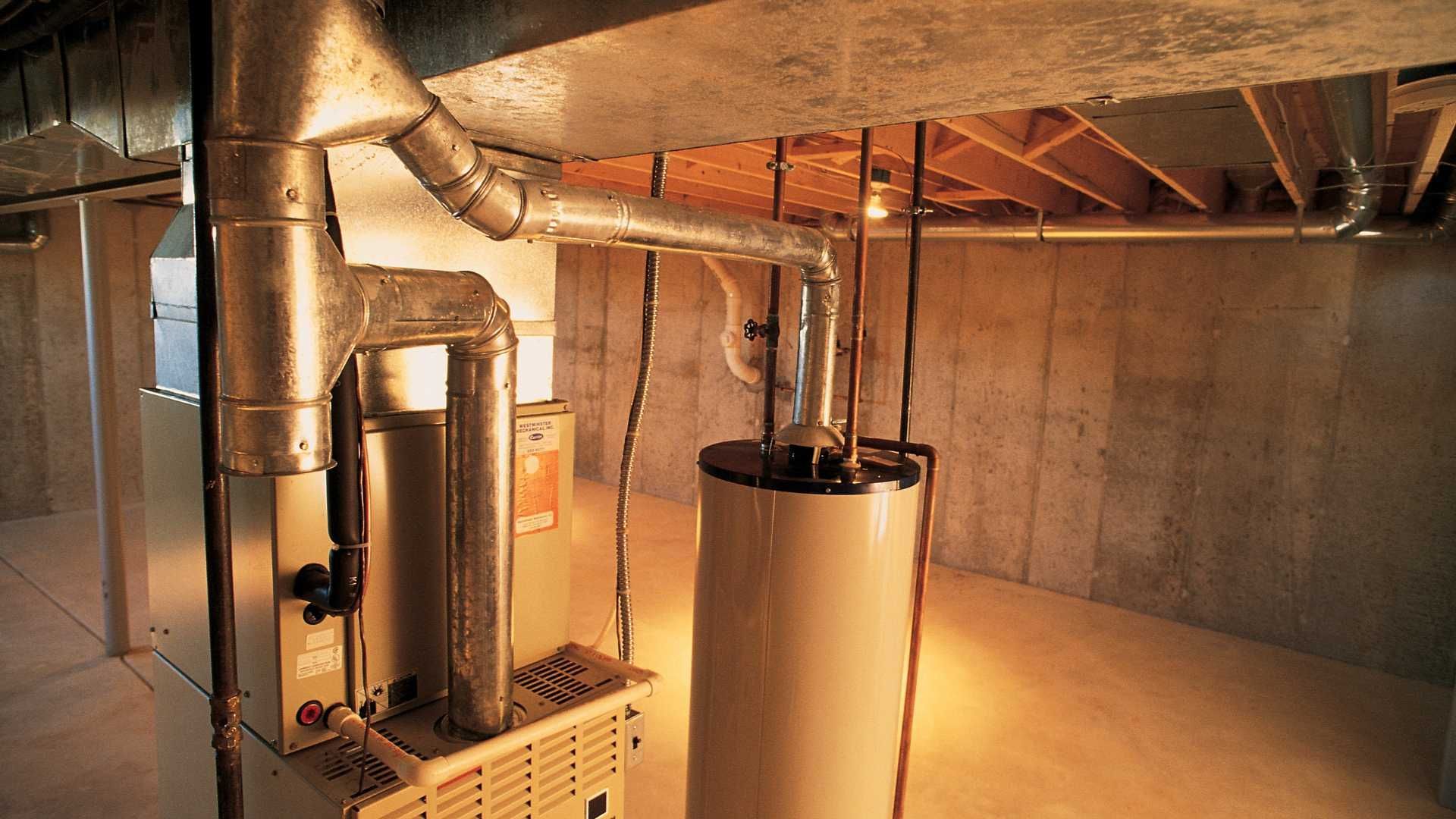A basement with a heater and a water heater in it.