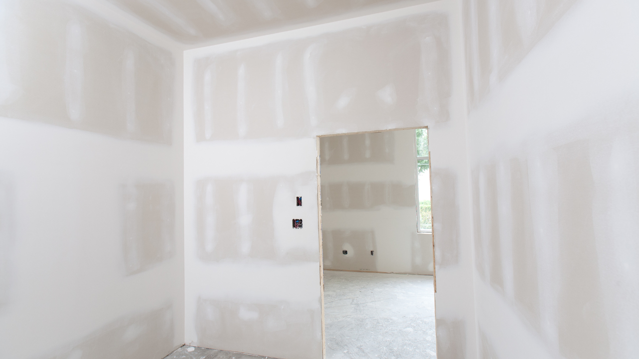 Interior view of room with drywall walls and doorway leading to another room.