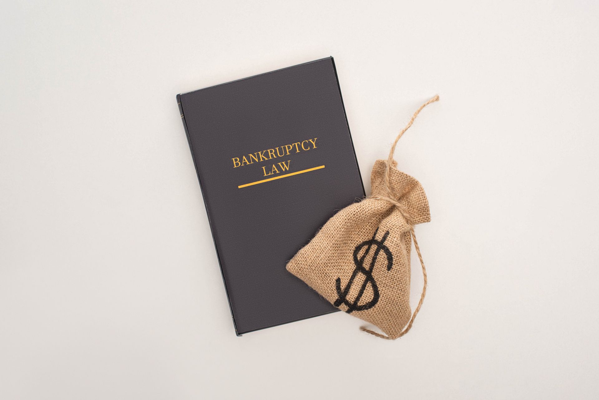 Black gift box and burlap money pouch with dollar sign on a white background