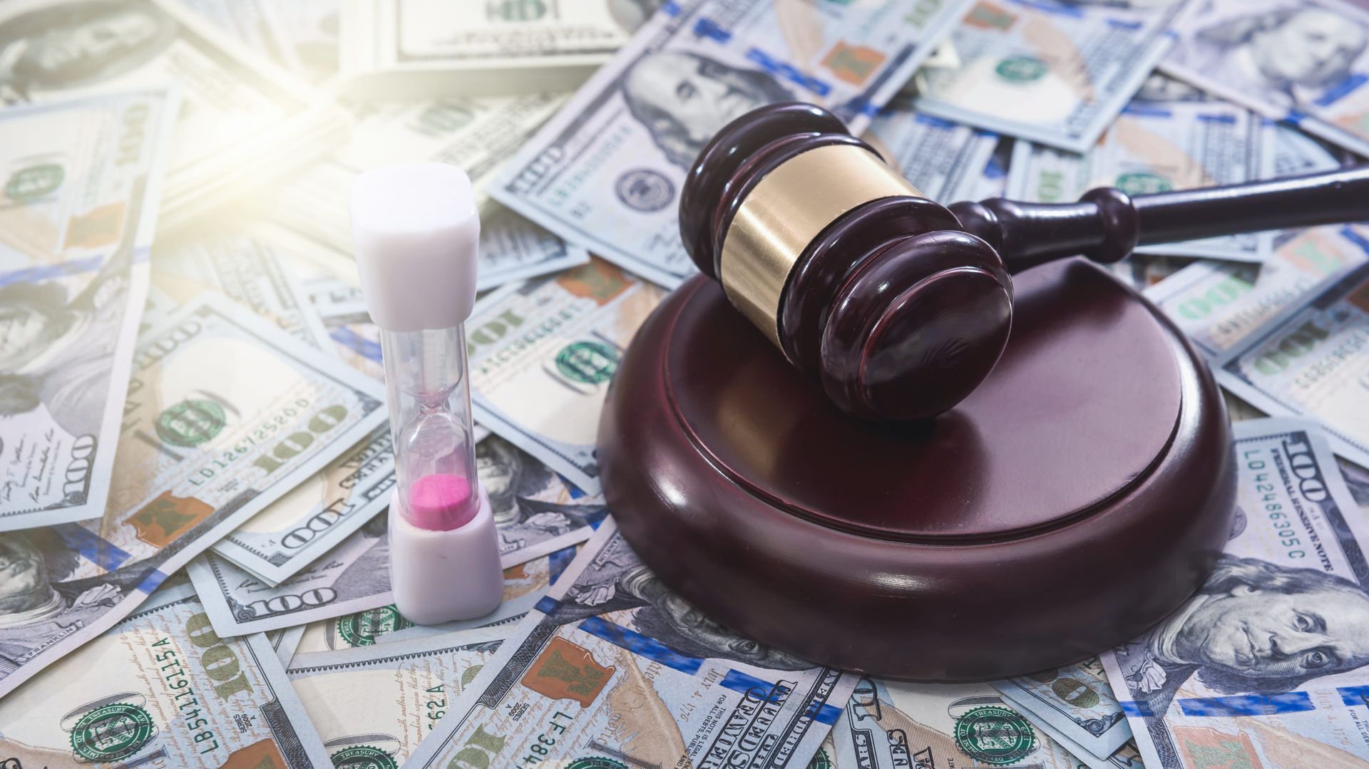 Judge’s gavel on a law book amid scattered U.S. dollar bills and a white pill bottle with capsules