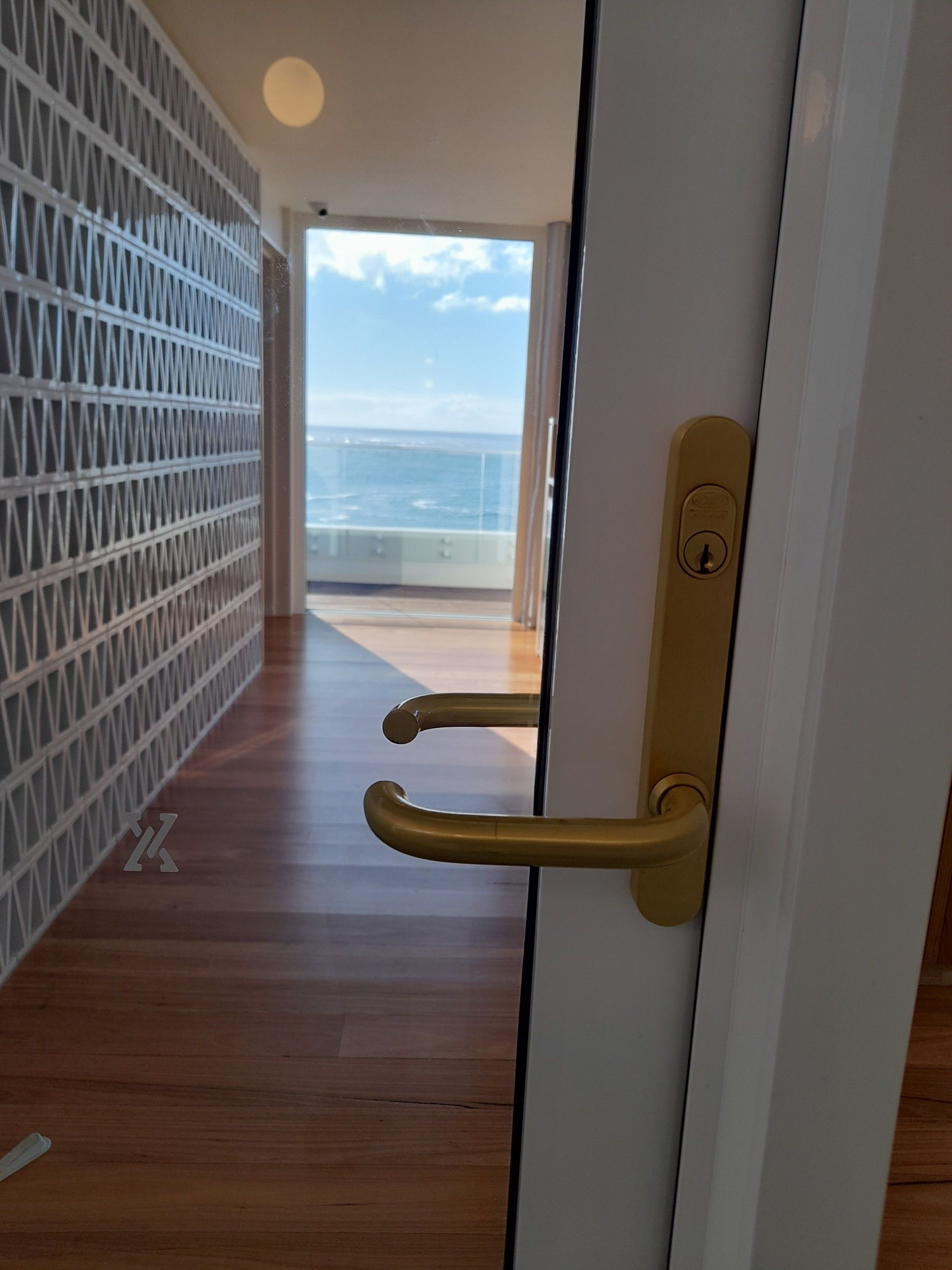 A Gold Padlock Securing a Storage Unit Door With a Red Plate  — Yamba Locksmiths in Yamba, NSW