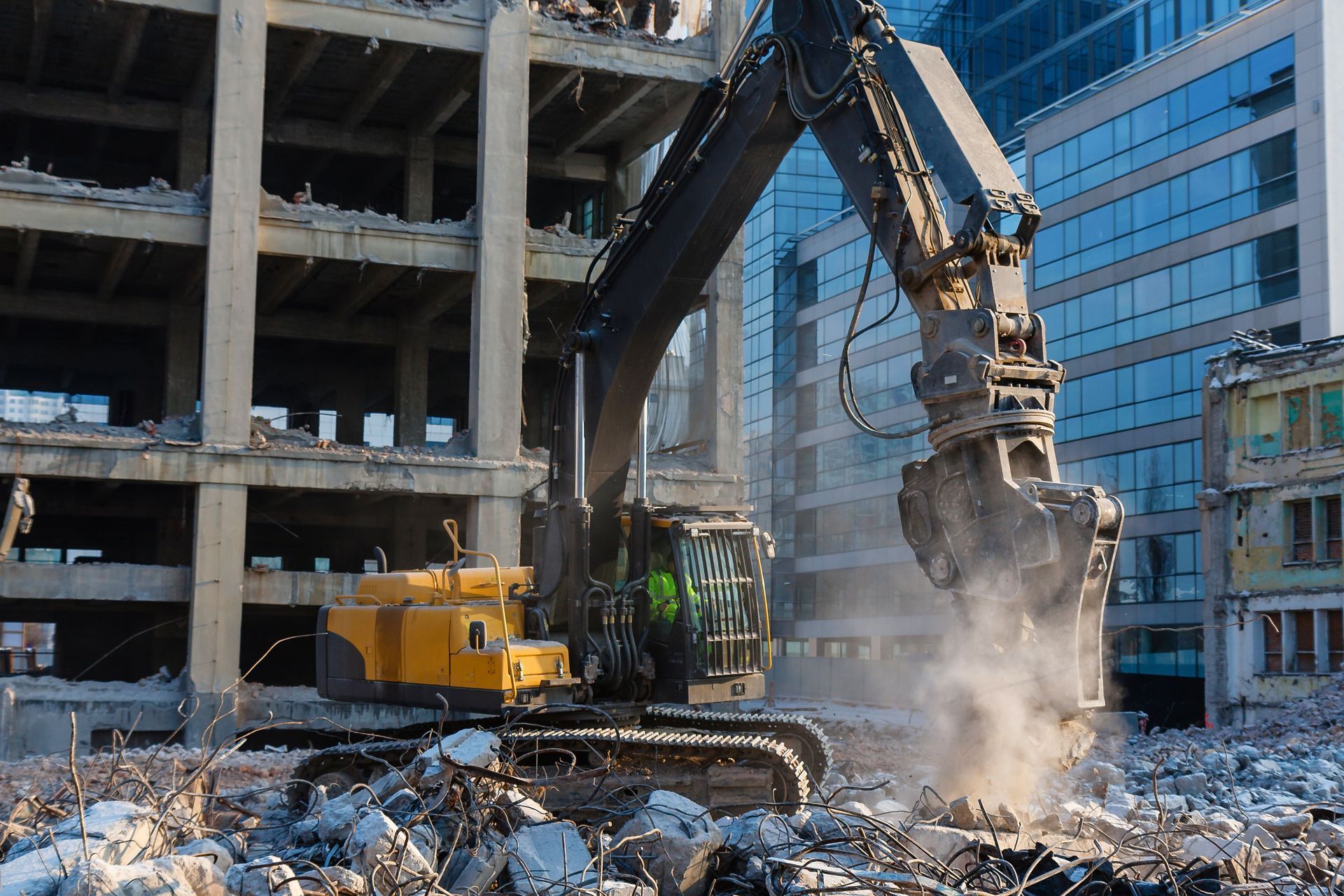 A large excavator is demolishing a building in a city.