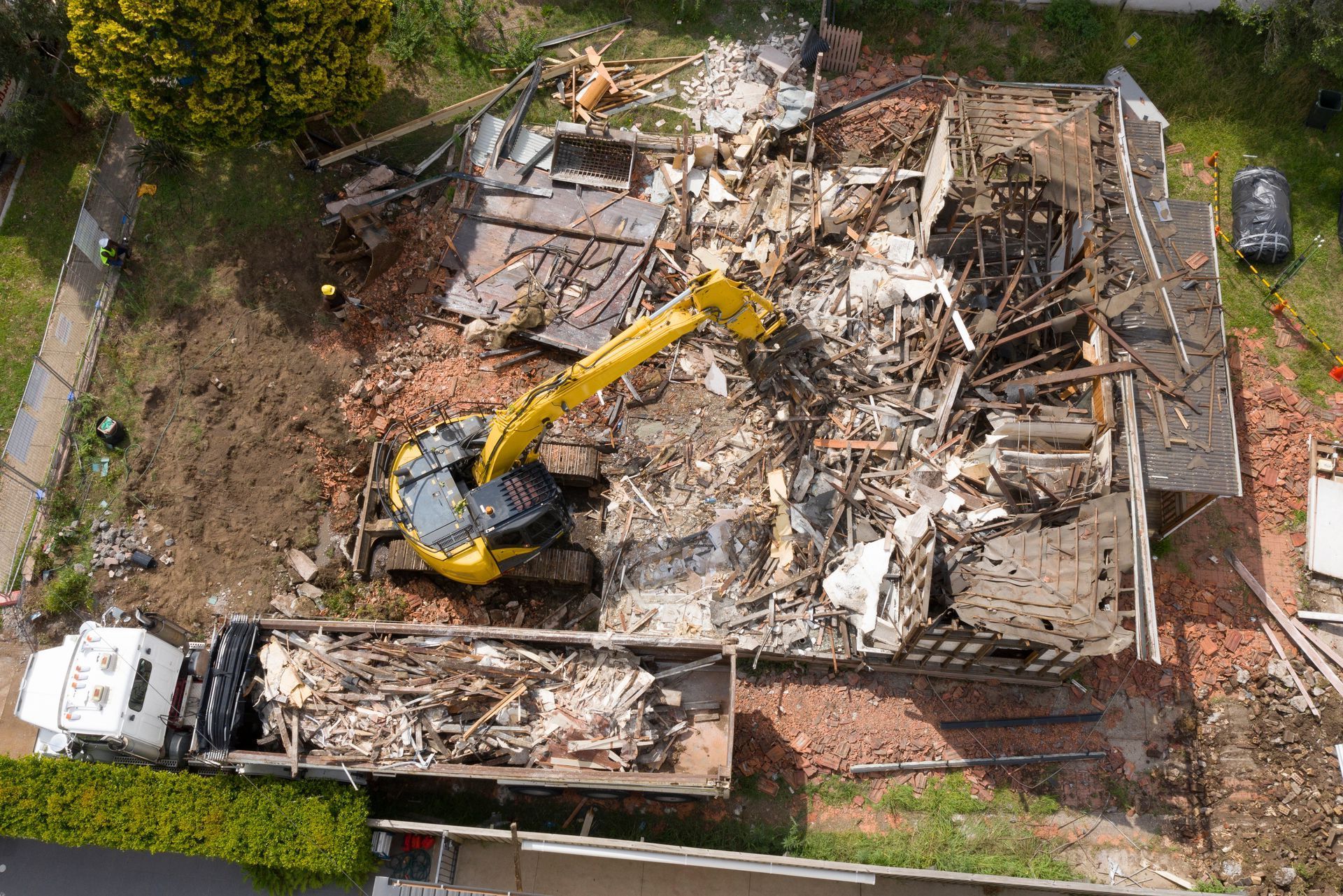 An aerial view of a large building in Greater Manchester being demolished.