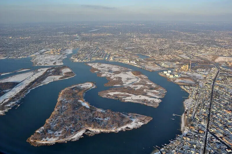 Aerial view of a river winding through a snowy city with islands and dense buildings on both banks