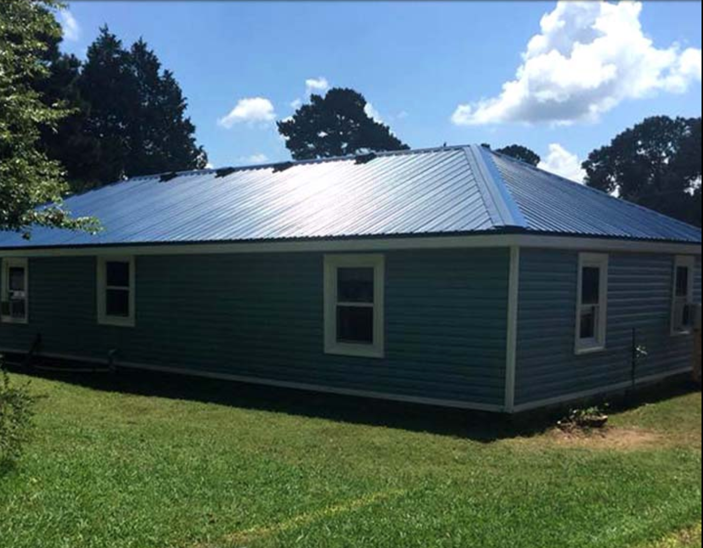 A blue house with a metal roof and white trim