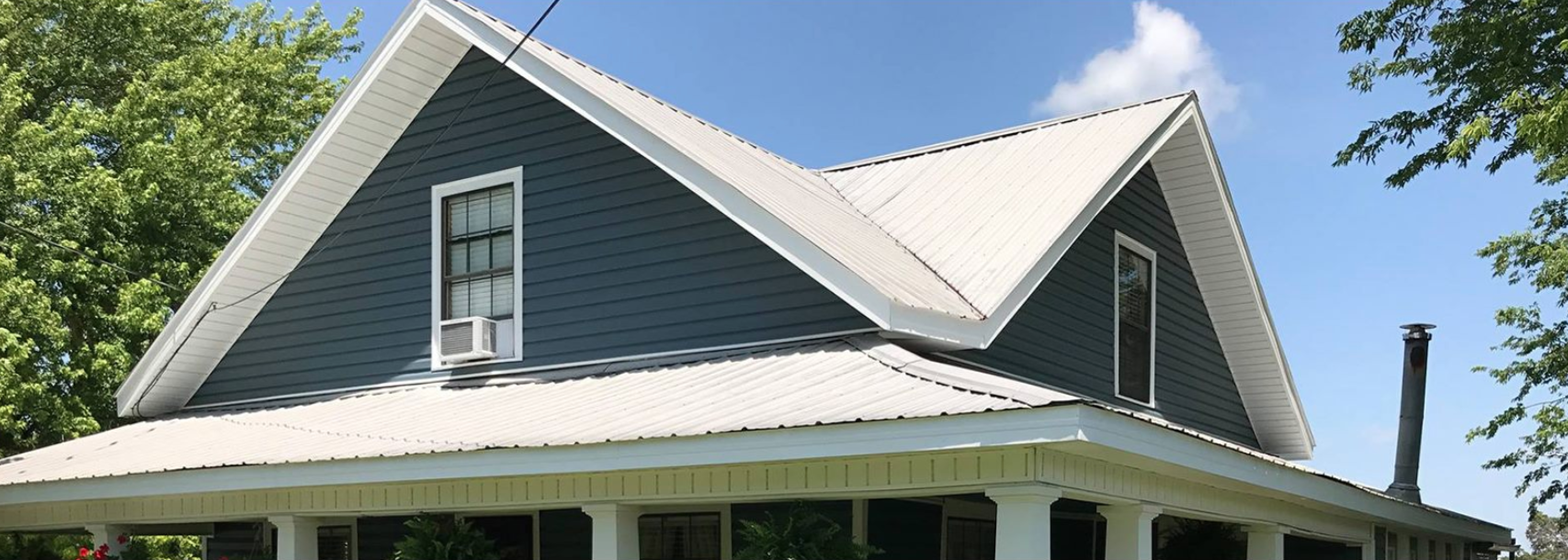 A house with a white roof and a porch on a sunny day.