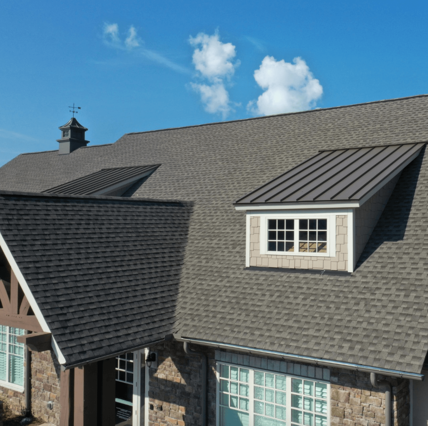 A house with a gray roof and a chimney on top