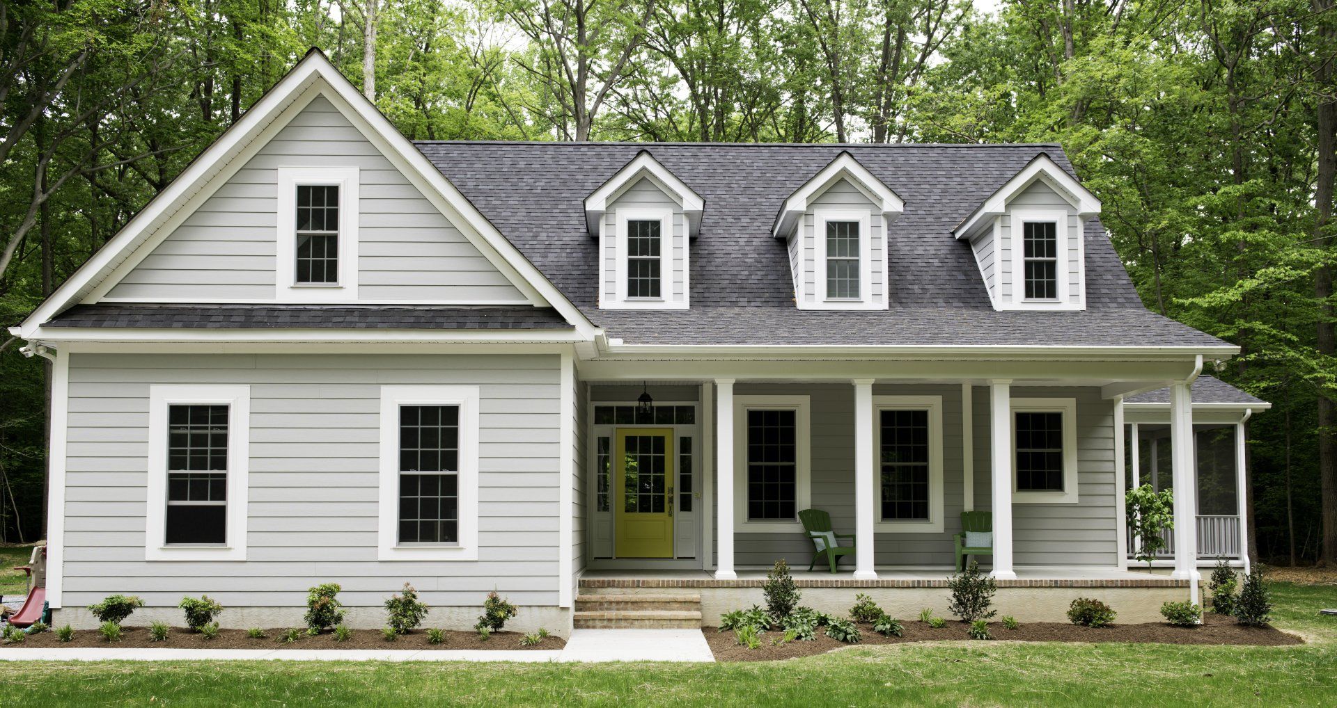 A white house with a gray roof and a yellow door
