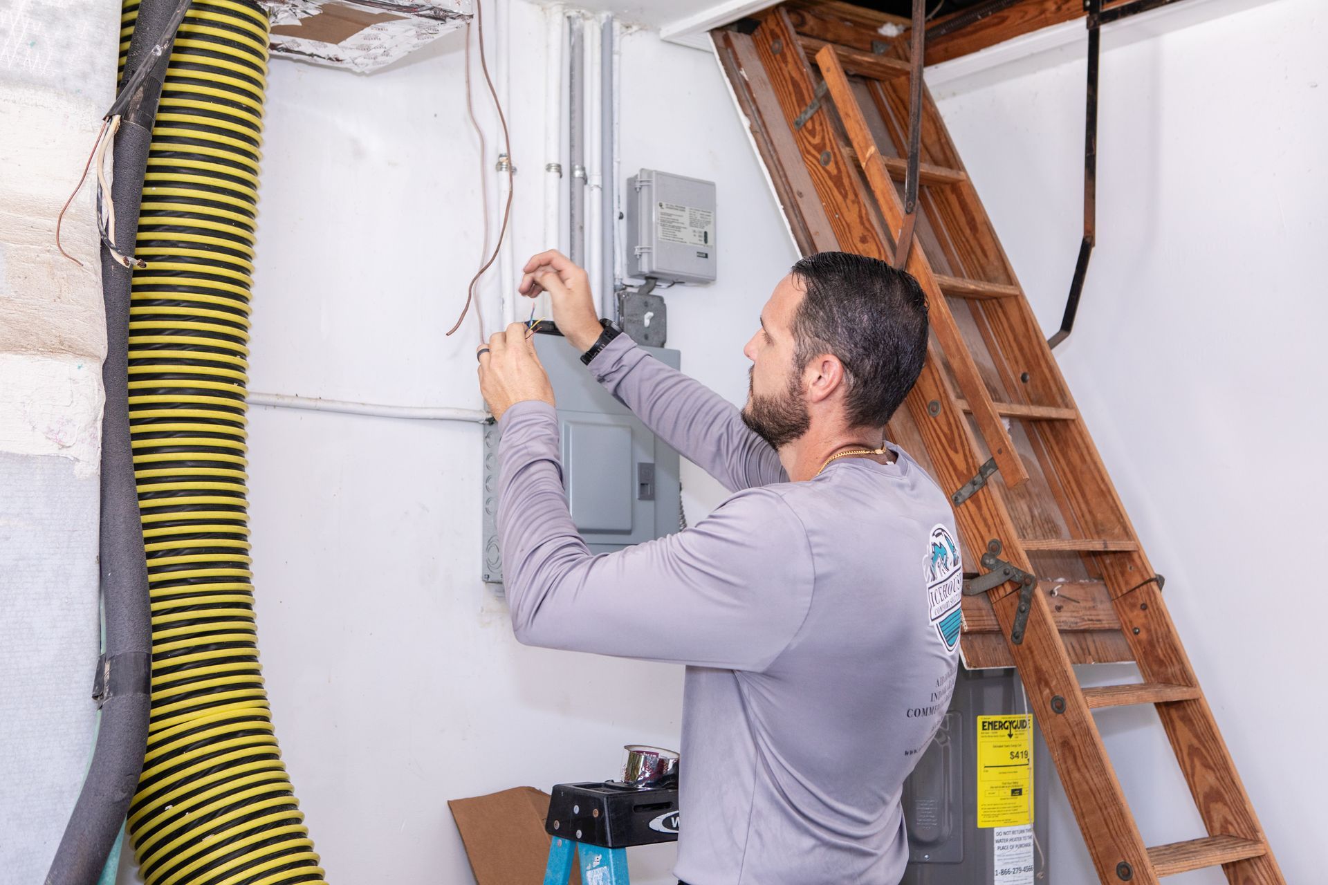 Technician in blue uniform inspecting an outdoor air conditioning unit with tools