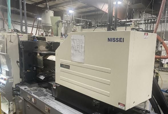 Injection molding machine by Nissei in a factory setting.