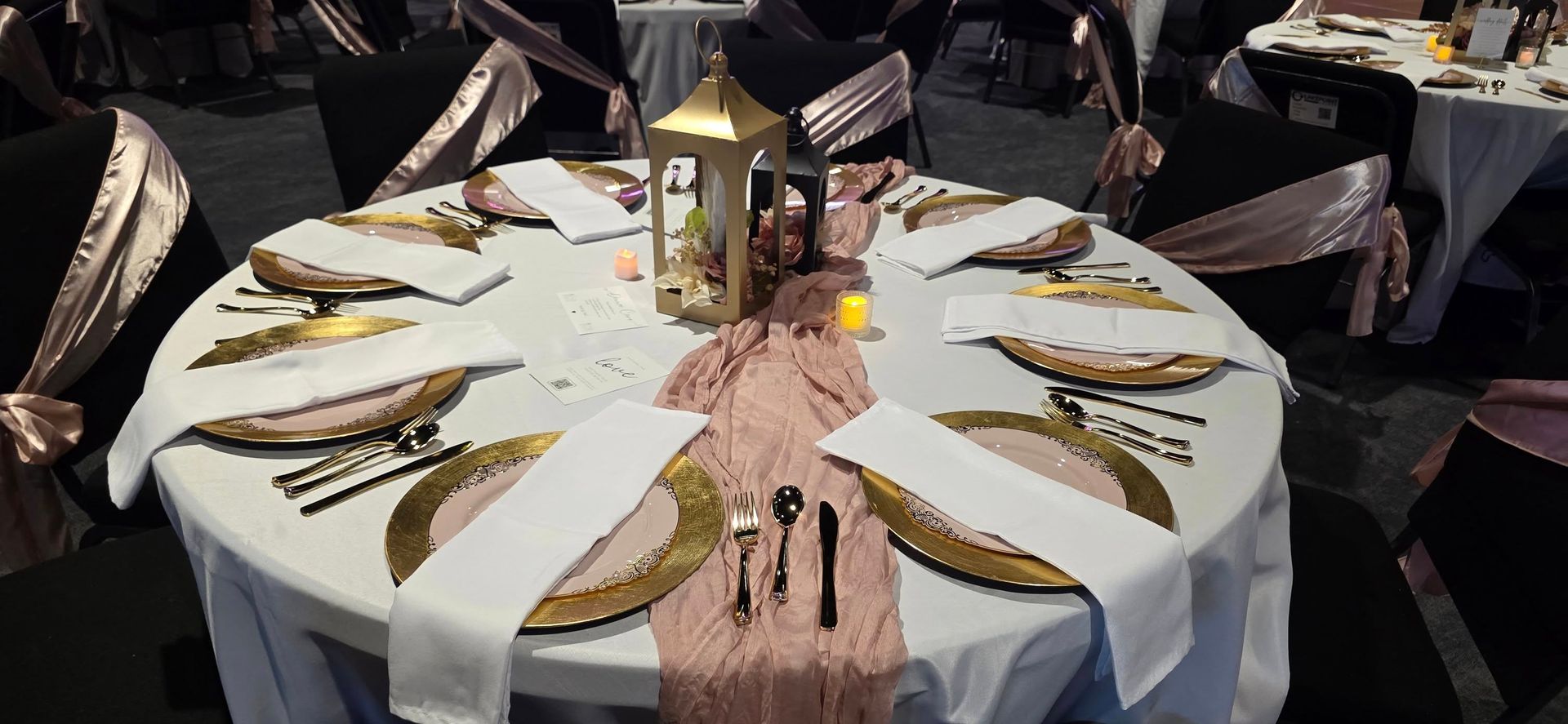 A table set for a formal event with gold chargers, white napkins, and pink accents.
With Love, Wedding management, Milwaukee Wedding Coordinator