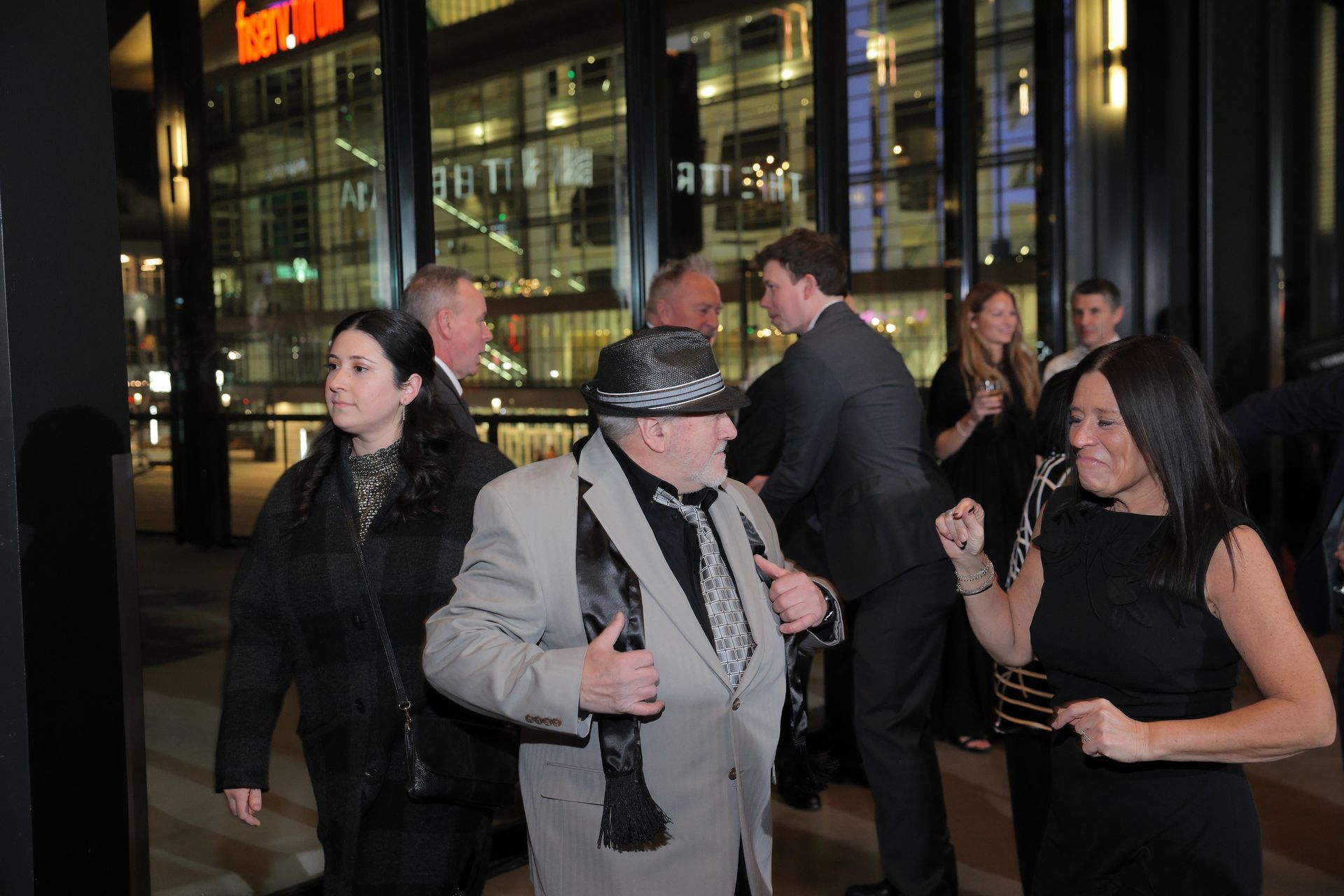 People exiting a building at night. A man in a hat is the central focus, accompanied by others in formal attire.
With Love, Wedding management, Milwaukee Wedding Coordinator
