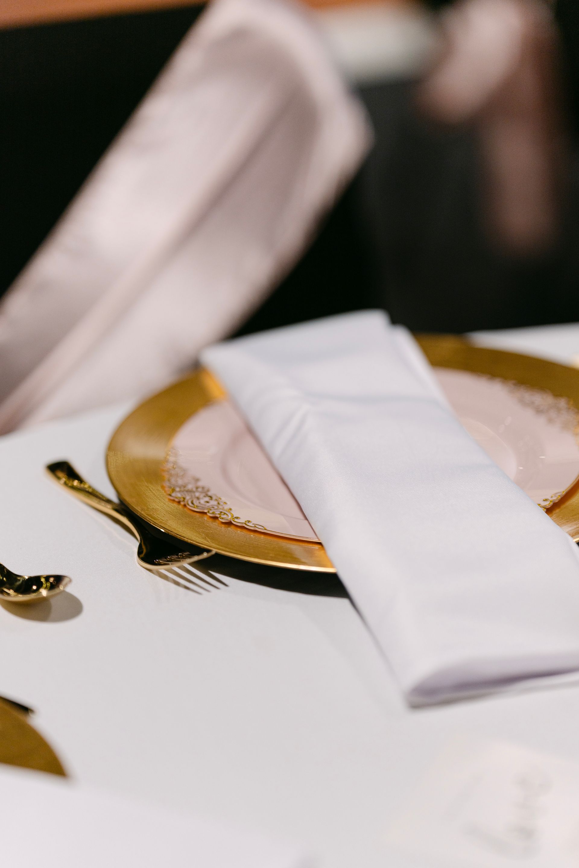 Close-up of a table setting: gold-rimmed plate with a white napkin, gold cutlery.
With Love, Wedding management, Milwaukee Wedding Coordinator