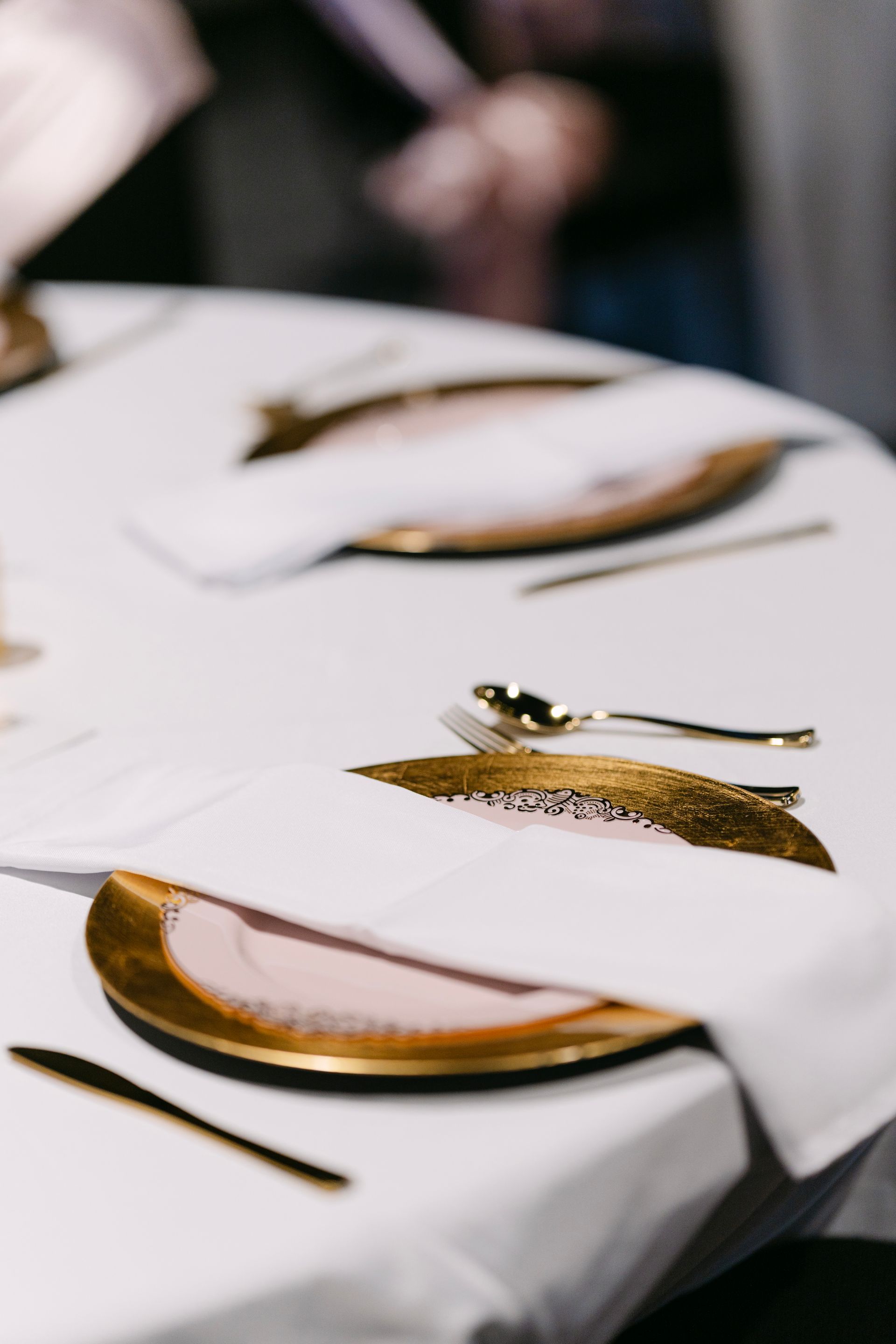 Table setting with gold-rimmed plates, silverware, and folded white napkins on a white tablecloth.
With Love, Wedding management, Milwaukee Wedding Coordinator