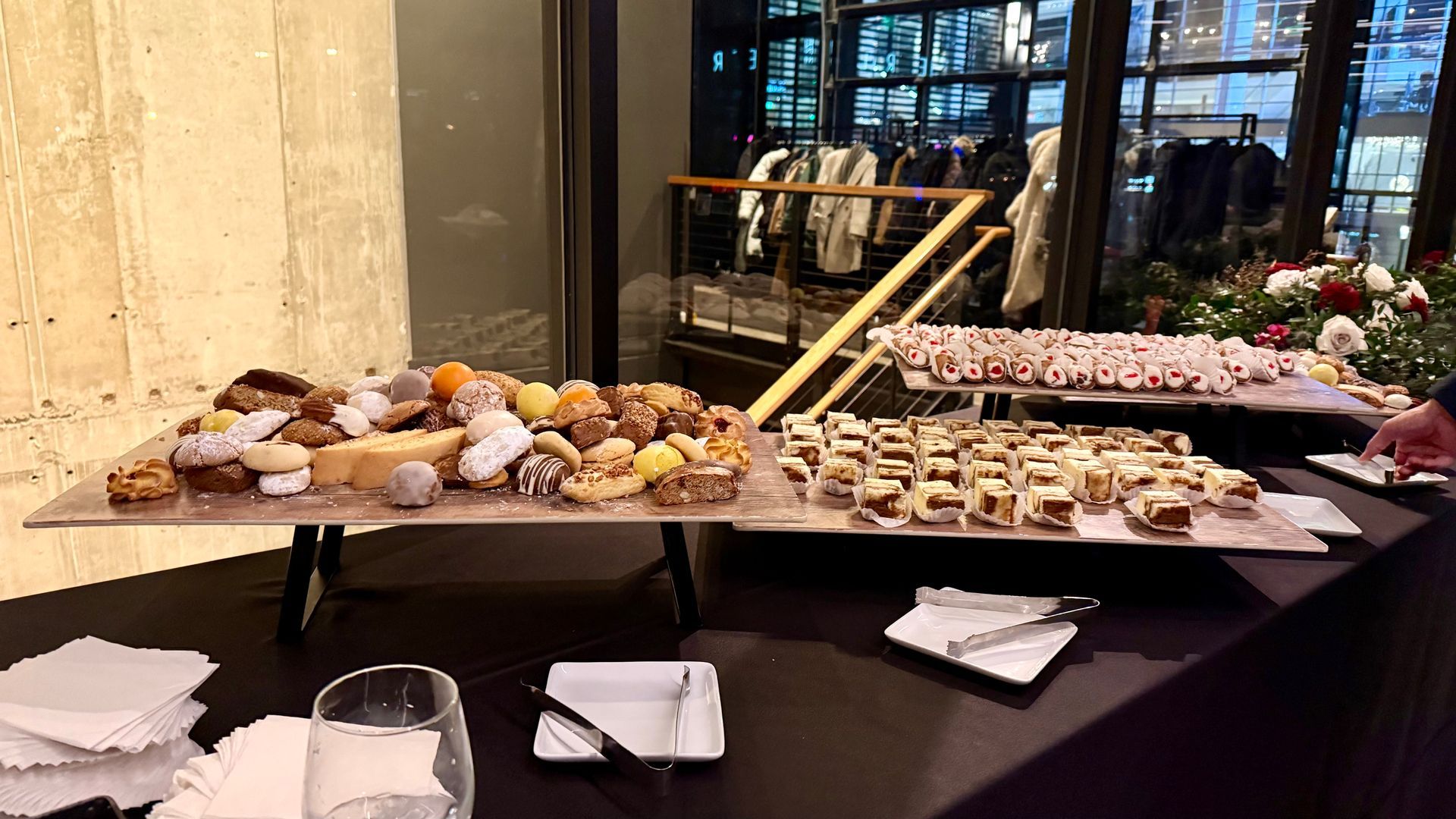 Dessert table with pastries. Beige and black, in a room with a large window and red floral arrangements.
With Love, Wedding management, Milwaukee Wedding Coordinator