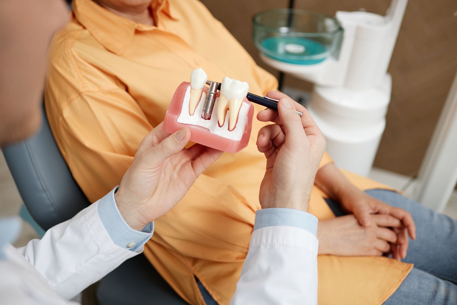 Learn more about our dental implants in Central, LA, or call us today! Dentist holding a dental implant display | Top Dental implants in Baton Rouge, LA