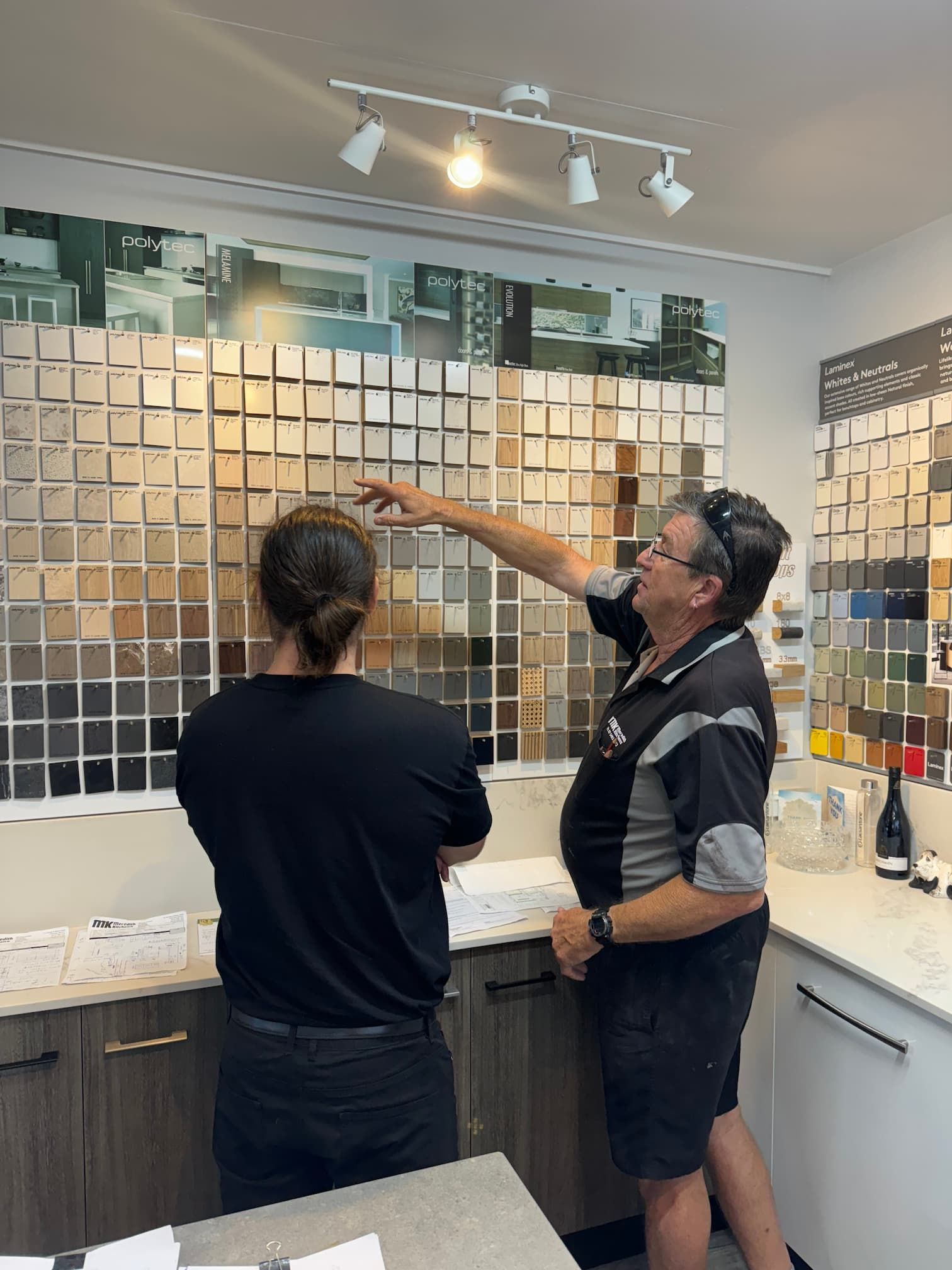 Two People Looking At Colour Swatches— Meredith Kitchens In Moffat Beach, QLD