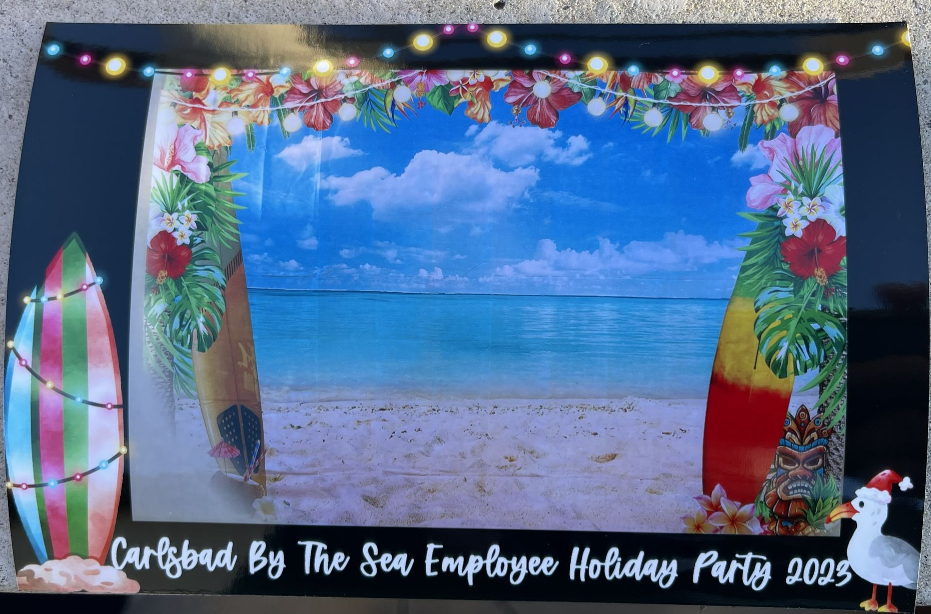 Caribbean beach party backdrop with palm decorations, ocean scene, and string lights for an employee holiday party