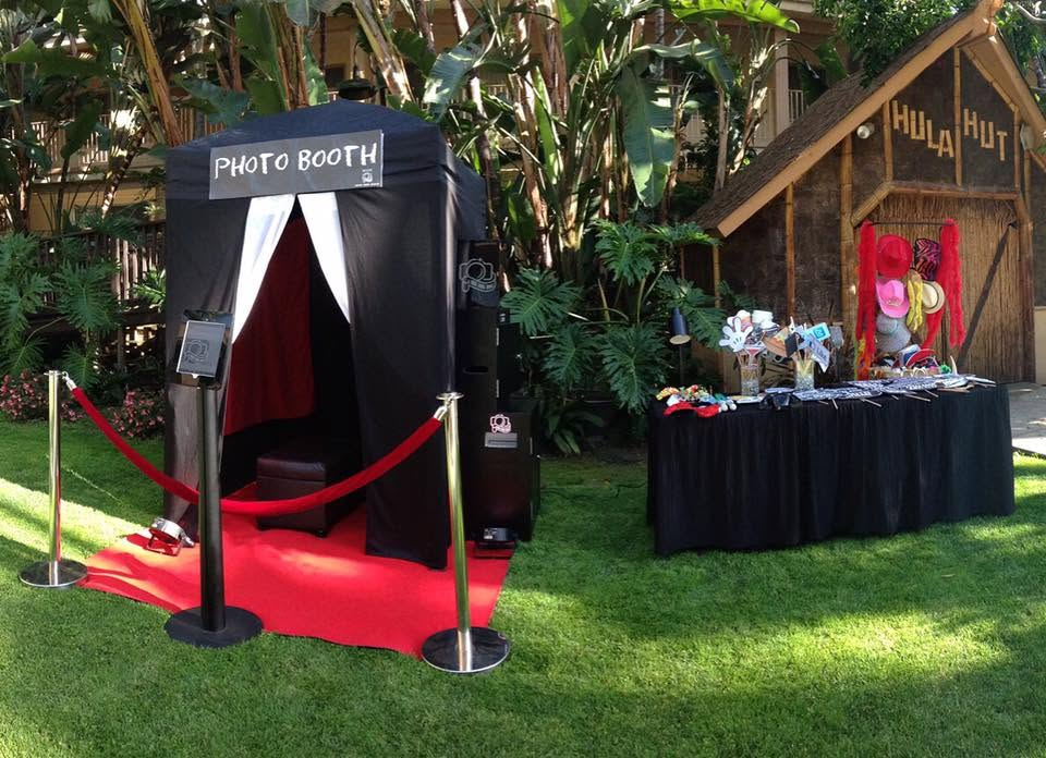 Halloween photo booth with red carpet, black curtains, and a decorated table outdoors