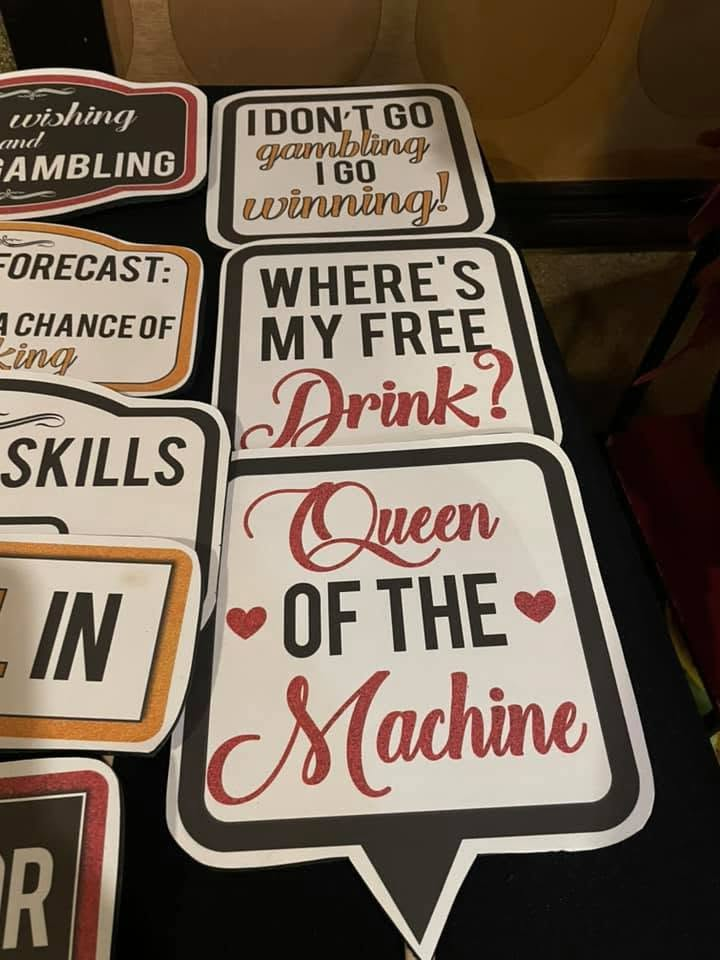 Stack of humorous bar signs, including “Where’s my free drink?” and “Queen of the Machine.”