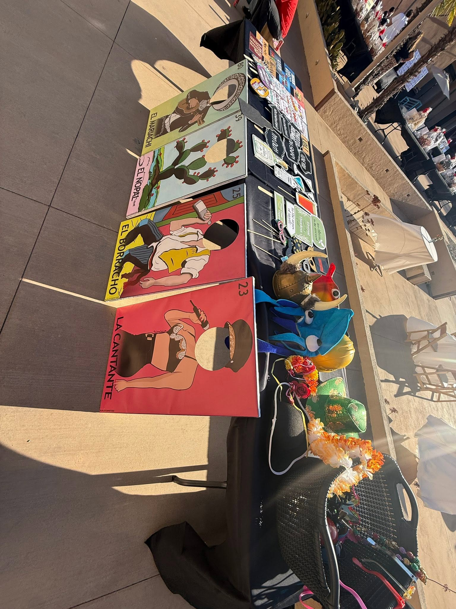 Outdoor market stall with colorful handmade cards and small trinkets displayed on a table.