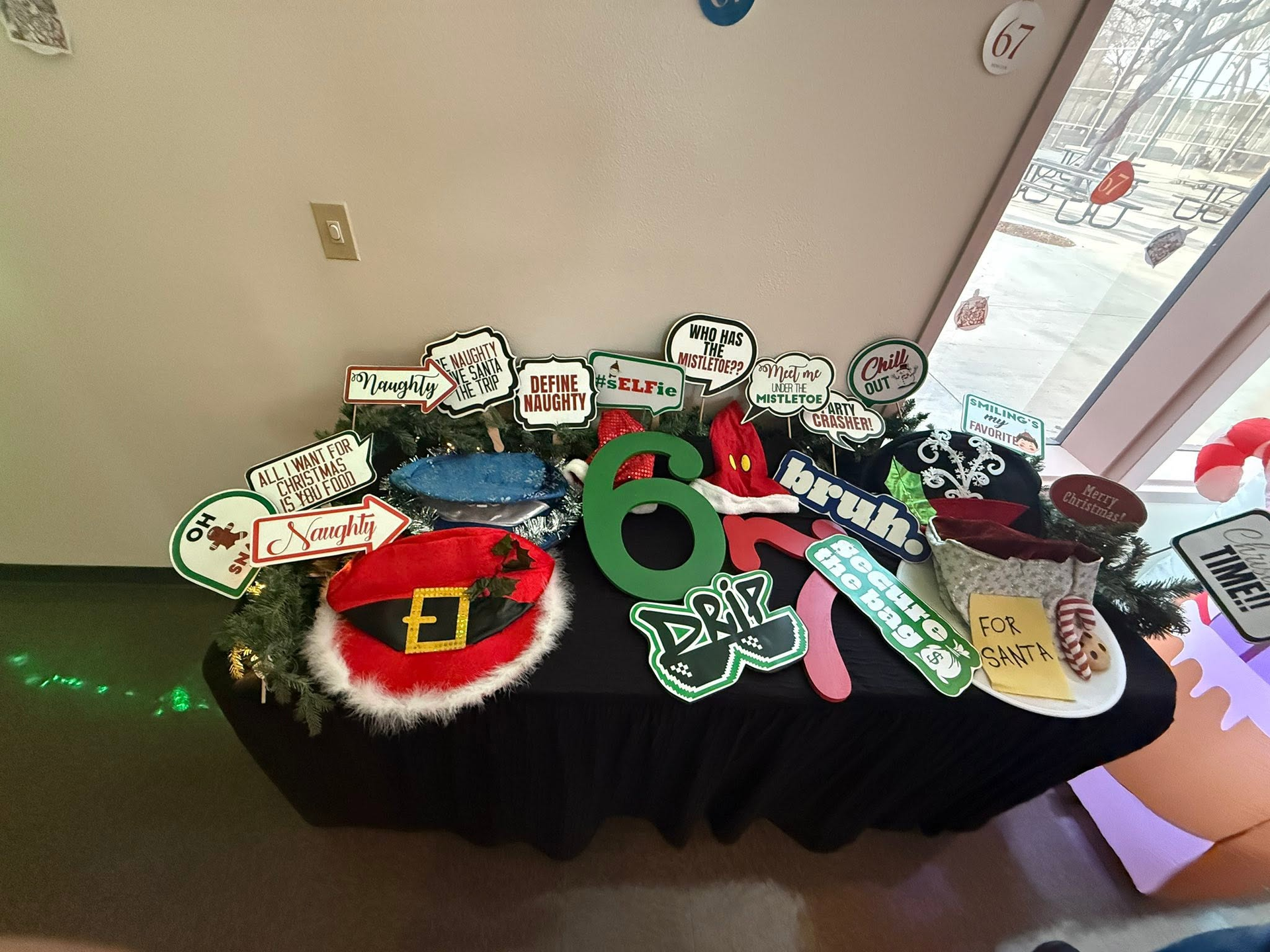 Table with colorful handmade signs and large green number 6 decorations displayed indoors