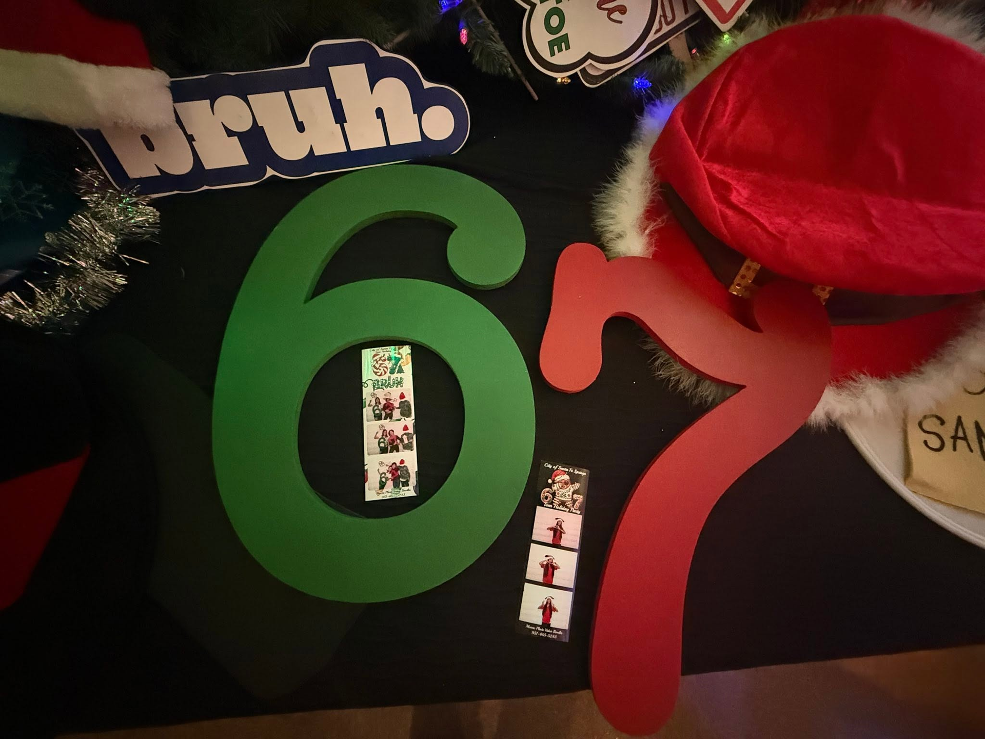Colorful “6” and “7” decorations with a red cap and small photo strips on a black background