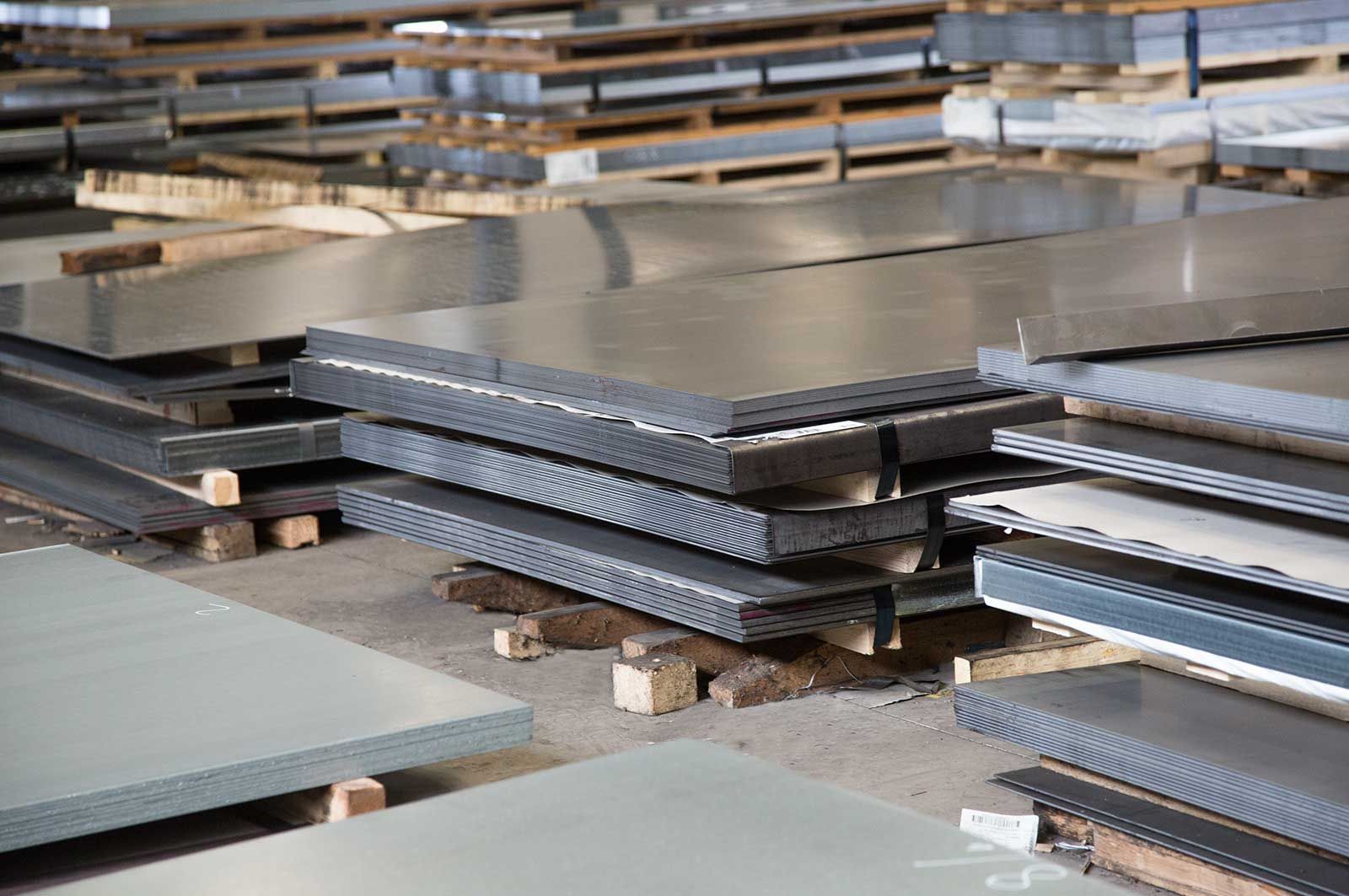 Una fila di lastre di copertura metalliche sono impilate l'una sull'altra.