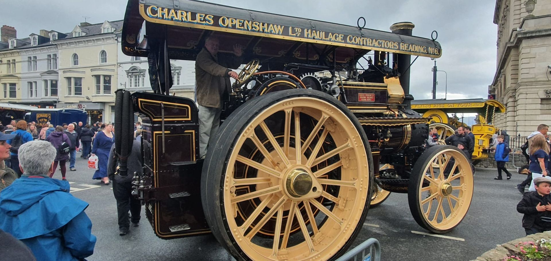 A large old steam engine is parked on the side of the road.