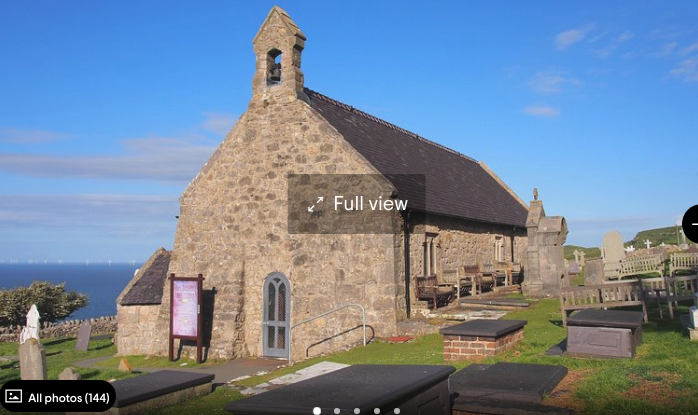 A full view of a church with a cemetery in front of it