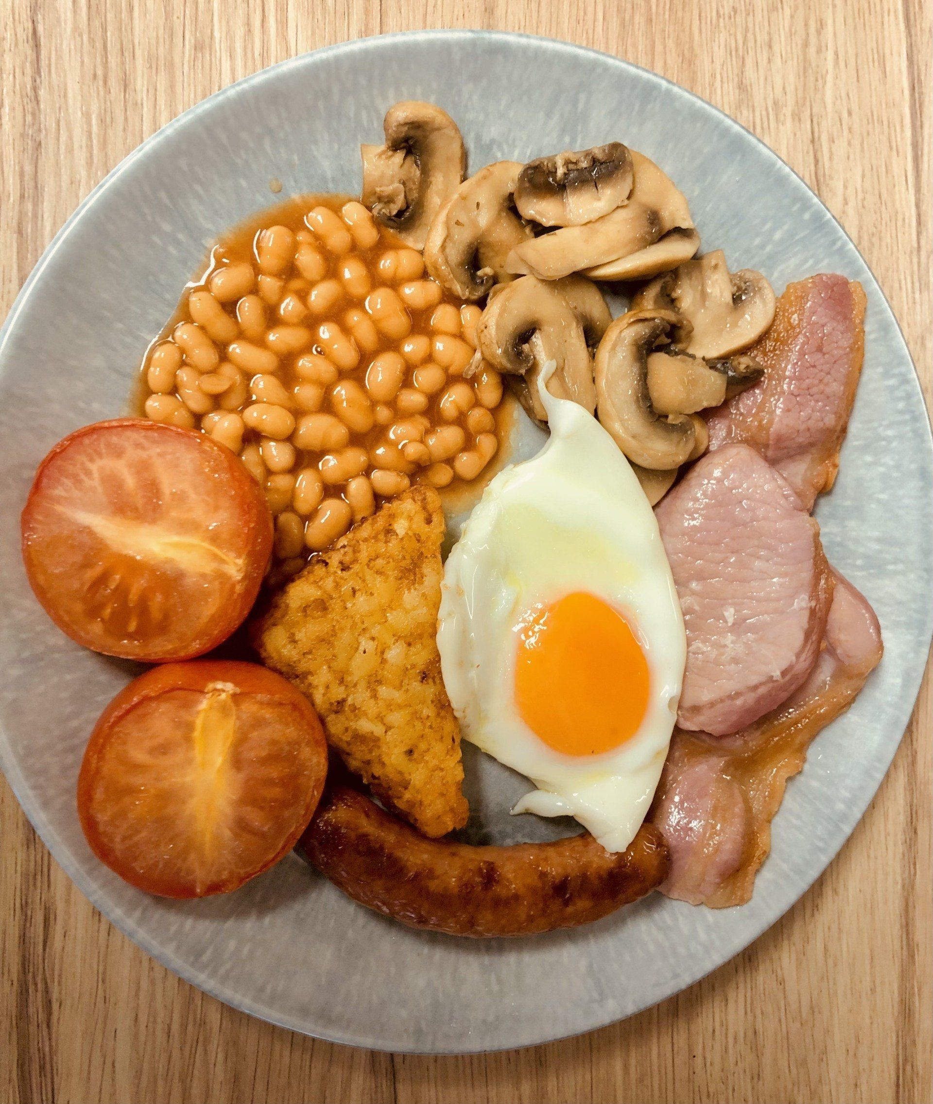 A plate of food with eggs beans mushrooms and tomatoes