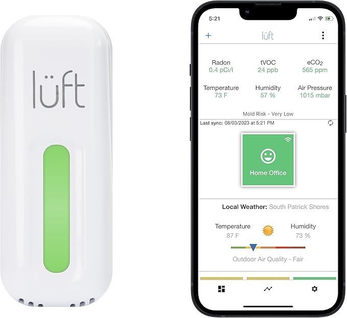 A white device with a green button next to a cell phone.