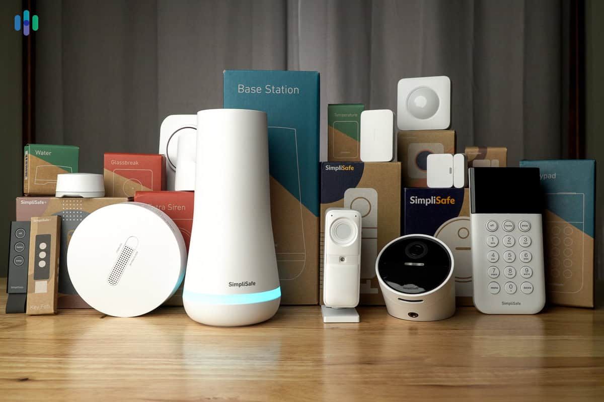 A bunch of smart home devices are sitting on a wooden table.