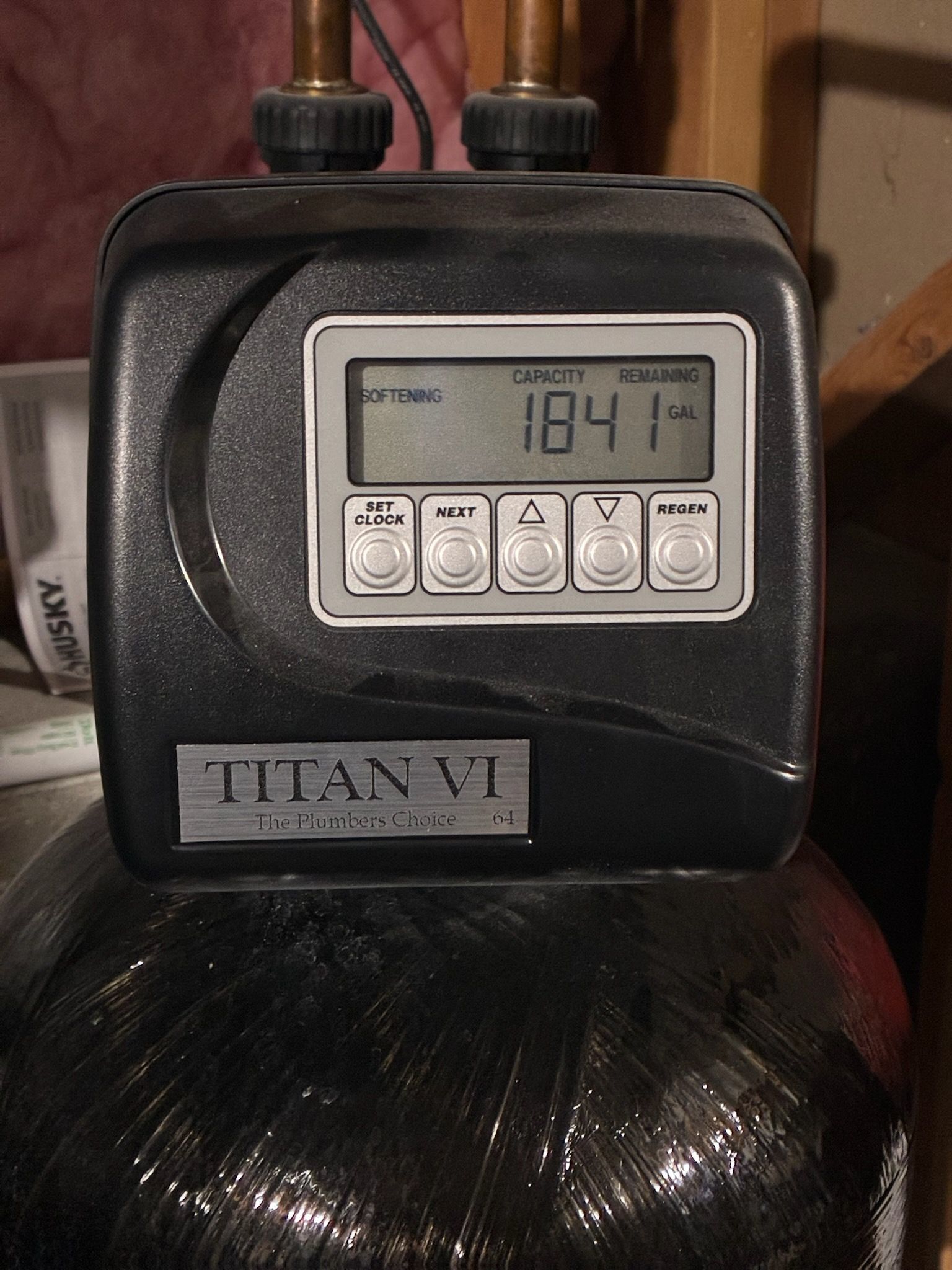 Digital water meter on a black tank labeled “TITAN VI,” showing a reading of 1841.